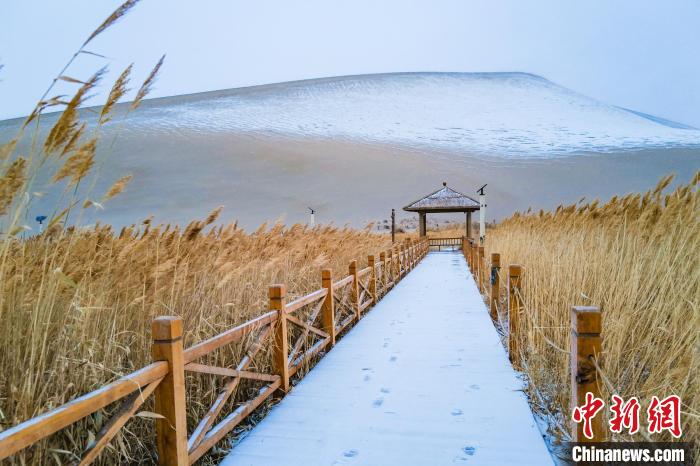2021年11月28日，在敦煌鳴沙山月牙泉景區(qū)，沙雪交融，更顯北國(guó)風(fēng)情?！⊥醣筱y 攝