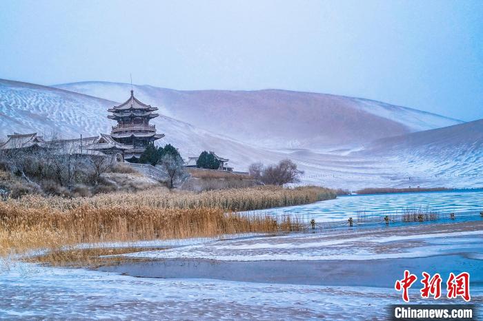 2021年11月28日，雪落鳴沙山月牙泉景區(qū)?！⊥醣筱y 攝