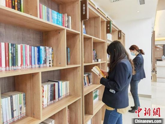 圖為在甘肅公航旅建設(shè)集團(tuán)有限公司的職工書屋，職工挑選書籍?！⌒煅?攝